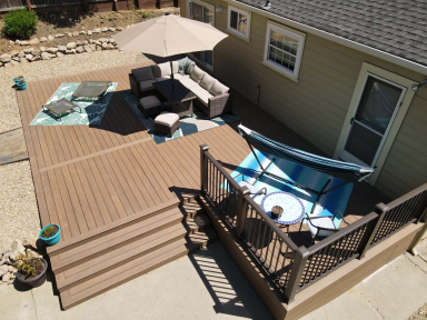 Aerial view of a patio deck with lounges, couches, umbrellas, and a hammock